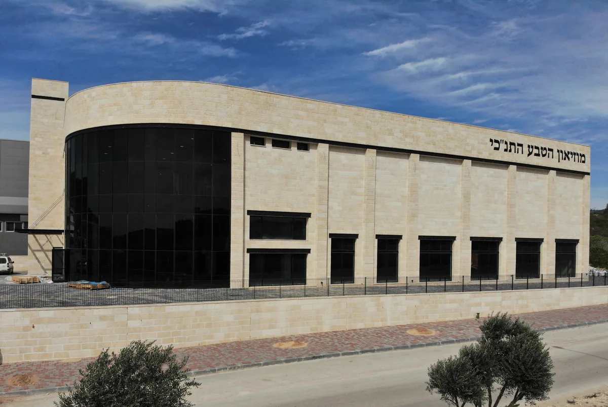 Stone-clad building of the Biblical Museum of Natural History with its name in Hebrew letters